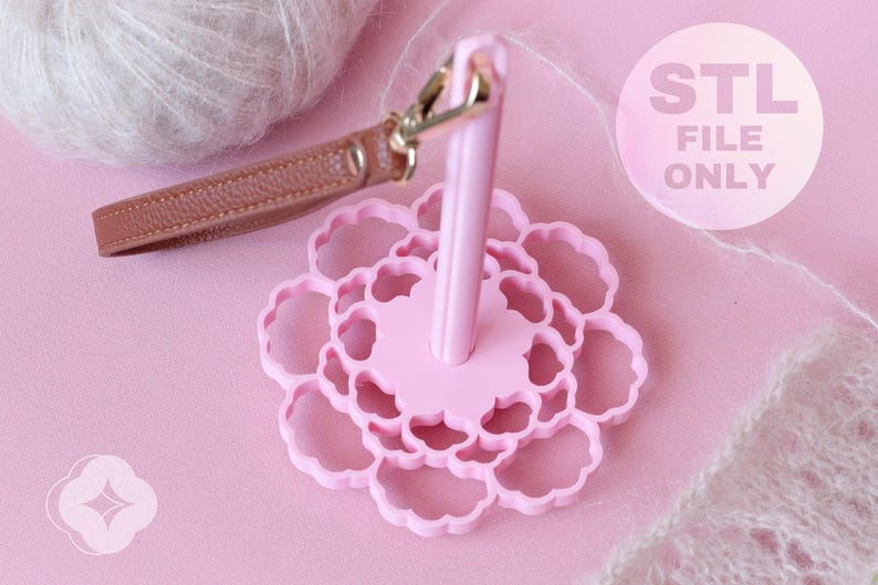 May include: A light pink yarn holder with a flower-shaped base and a central vertical spindle. A brown leather wrist strap with a gold-tone metal lobster clasp is attached to the top of the spindle. The text STL FILE ONLY is visible.