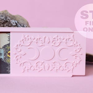 May include: A light pink rectangular sliding box featuring an embossed triple moon symbol surrounded by ornate scrollwork. A tarot card is partially visible inside the box. The text STL FILE ONLY is printed in a white circle on the right side.