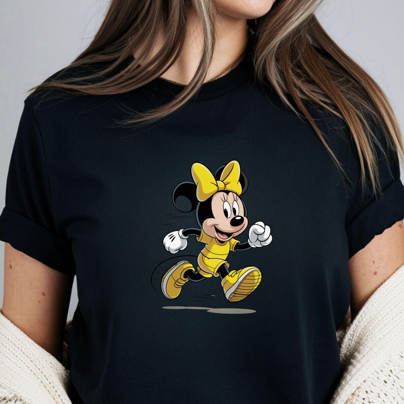 May include: Black t-shirt featuring a cartoon image of Minnie Mouse in a yellow outfit and bow, running. The graphic is a vibrant illustration with a white outline, set against the dark fabric of the shirt.