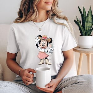 May include: A white ceramic mug with a black handle and the text "But First, Coffee" in a black, handwritten-style font. The mug is on a white surface.