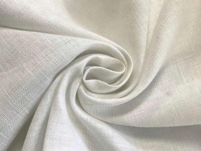 May include: A piece of white fabric with a visible woven texture, arranged in a swirling, gathered pattern that creates soft folds and shadows. The material has a matte finish and a consistent, neutral white color throughout the entire surface.