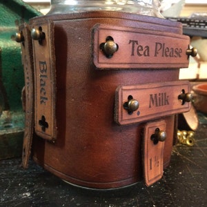 Adaptable Steampunk style mason jar mug cozy made from full grain veg tan leather. Free UK delivery.