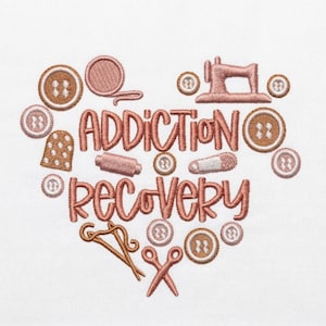 May include: Embroidered design in the shape of a heart with the words "Addiction Recovery". The design includes sewing notions such as buttons, a thimble, scissors, and a sewing machine, all in shades of brown and pink.