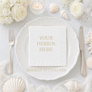 May include: A white square napkin with the text "YOUR DESIGN HERE" is centered on a white plate. A fork and knife are on either side of the plate. The scene is decorated with white flowers, seashells, and a lit candle.