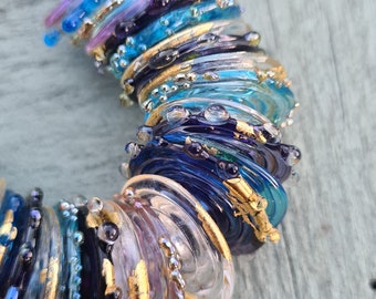 Handmade Murano glass disc beads in shades of purple, lilac, turquoise and clear with  24k gold leaf and silver rich glass details