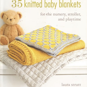 May include: A book titled "35 Knitted Baby Blankets" for the nursery, stroller, and playtime by Laura Strutt. The cover features a stack of three knitted baby blankets in yellow and gray.