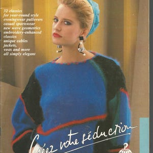 May include: Cover of "Knitting Elegance" magazine. The cover features a woman wearing a blue sweater with black and red accents. The magazine title is at the top, with text promoting knitting patterns.
