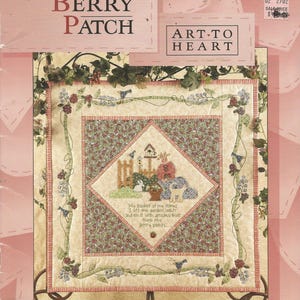 May include: A quilt pattern titled "In My Berry Patch" with a central diamond design featuring a garden scene with a birdhouse, rabbits, and a dog. The quilt is decorated with floral vines and the text "Art to Heart".