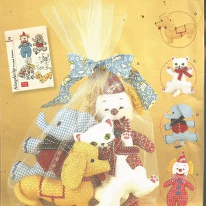 May include: Simplicity sewing pattern featuring stuffed animal designs. The pattern includes a clown, elephant, cat, dog, and other animal shapes. The pattern is labeled "One Size" and includes the Simplicity logo.