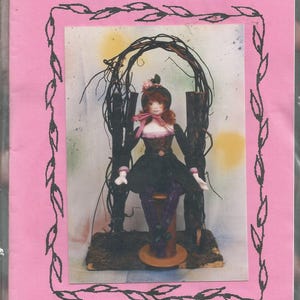 May include: A pink package with a doll inside. The doll is wearing a black dress, a pink bow, and a black hat. The package has the text "Barbara Willis Designs Truffle" and "14" Doll A Sweet Elf".