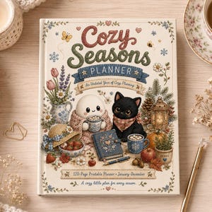 May include: A cream-coloured planner titled Cozy Seasons Planner with a 120-page printable planner January-December label. The cover features a white round character, a black cat, a blue book, a pen, flowers, strawberries, and a lantern.