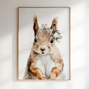 May include: A framed wall art print featuring a detailed illustration of a brown squirrel with a white chest. The squirrel is wearing a delicate floral crown made of small white and light purple flowers on its head, set against a plain background.
