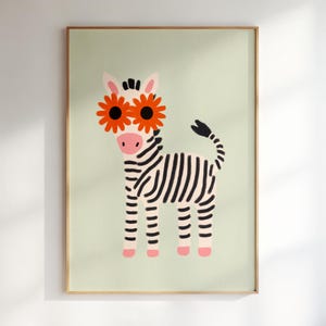 Op de afbeelding: Een ingelijste kunstdruk met een grillige zebra-illustratie. De zebra heeft zwart-witte strepen, roze hoeven en draagt een oranje zonnebloembril. De achtergrond is lichtgroen.