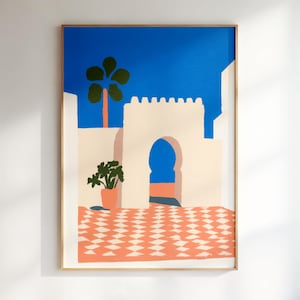 May include: A framed art print depicting a vibrant scene with a blue sky, a palm tree, and a building with an arched doorway. The artwork features a terracotta-colored tiled floor and a potted plant, creating a colorful, abstract landscape.