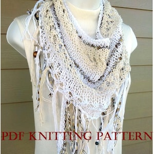 Op de afbeelding: Witte gehaakte sjaal met bruine en witte kralen en franjes. De sjaal is gedrapeerd over een wit mannequin. De tekst "PDF KNITTING PATTERN" staat onderaan de afbeelding.