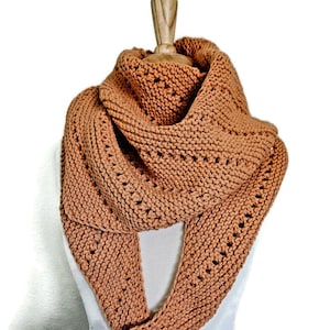 Peut inclure: Écharpe infinie tricotée de couleur rouille, présentée sur un mannequin. L'écharpe présente un motif tricoté texturé avec de petites ouvertures espacées. L'écharpe douce et chaude est conçue pour être portée autour du cou et des épaules.