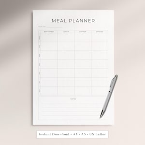 Pode incluir: Uma folha de planeamento de refeições branca com texto e linhas de grelha pretas. O cabeçalho diz MEAL PLANNER e WEEK OF. As colunas estão rotuladas como BREAKFAST, LUNCH, DINNER e SNACKS. As linhas vão de MON a SUN. Inclui uma caneta prateada.
