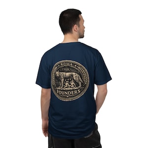 May include: Navy blue t-shirt featuring a circular graphic with a wolf nursing two infants, surrounded by text that reads "ROMA SPQR" and "FOUNDERS". The graphic is in a vintage style.