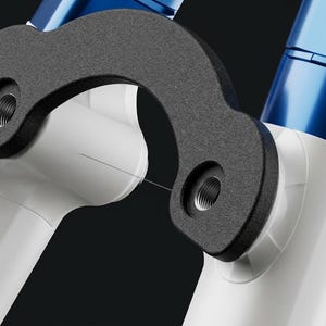 May include: Close-up of a bicycle suspension fork with a black, curved component and white tubes. The fork has blue accents and threaded holes for mounting. The design is modern and sleek.