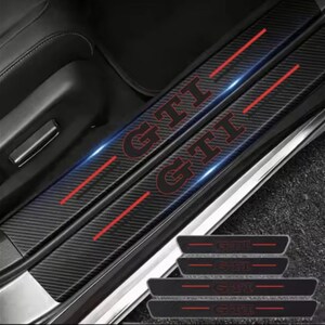 May include: Black car door sill protectors featuring the red letters "GTI" and red accent lines. The protectors have a carbon fibre texture. Additional smaller protectors are visible at the bottom of the image.