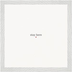 Könnte beinhalten: Gerahmter Druck mit weißem Hintergrund und hellgrauem Holzrahmen. Die Worte "stay here" sind in dunkelgrauer Schrift gedruckt, mit einem kleinen roten Punkt darunter.
