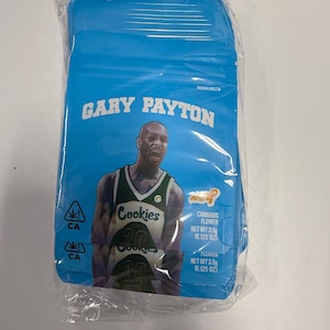 Pode incluir: Uma embalagem azul sel&aacute;vel com o texto "GARY PAYTON" e uma imagem de um jogador de basquete. A embalagem tamb&eacute;m exibe o logotipo "Cookies", s&iacute;mbolos de cannabis e o texto "CANNABIS FLOWER NET WT 3,5g (0,125 OZ)".