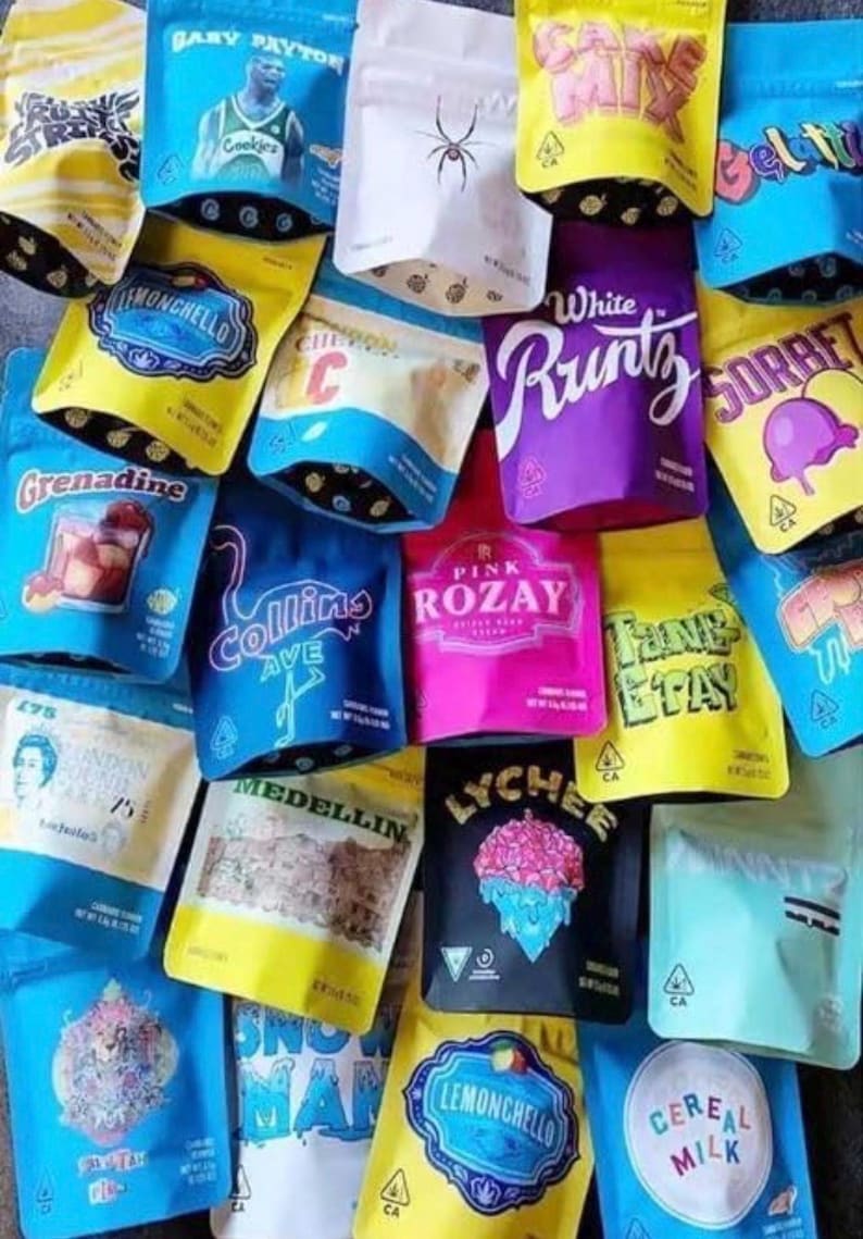May include: A collection of colorful, sealed pouches with various designs and text. The pouches feature text such as "Baby Payton," "White Runtz," "Lemonchello," and "Cereal Milk." The pouches are in shades of blue, yellow, purple, pink, and white.