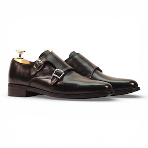 Sapatos Double Monk Strap, em couro preto de flor integral com fivelas ajustáveis.