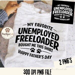 May include: White t-shirt with the text "MY FAVORITE UNEMPLOYED FREELOADER BOUGHT ME THIS SHIRT HAPPY FATHER'S DAY" in black. The shirt also features paw prints. A small black square with the same text is in the upper right corner.