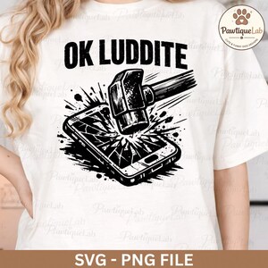 May include: White t-shirt featuring a black graphic of a hammer breaking a smartphone, with the words "OK LUDDITE" above. The text "SVG - PNG FILE" is below the graphic. A humorous design.