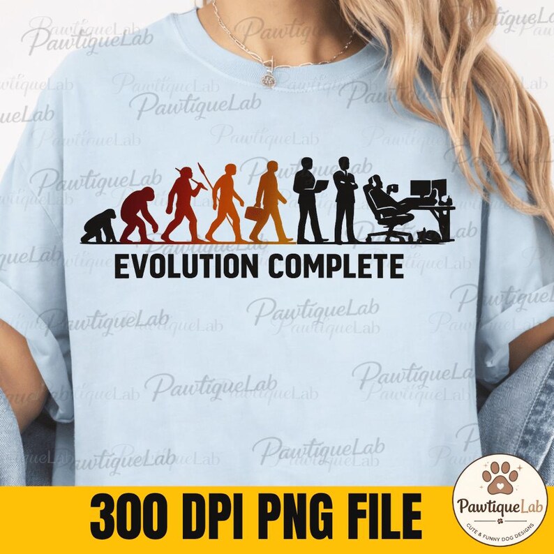 Pu&ograve; includere: Una t-shirt azzurro chiaro con una stampa grafica della sequenza dell'evoluzione umana, che passa da un primate a una persona seduta a una scrivania. Il testo "EVOLUTION COMPLETE" &egrave; stampato in grassetto nero con lettere maiuscole.