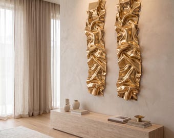 May include: Two vertical wall sculptures made of polished gold-toned metal with a highly reflective, rippled, and undulating surface texture. These elongated rectangular pieces feature deep folds and organic curves that catch the light.