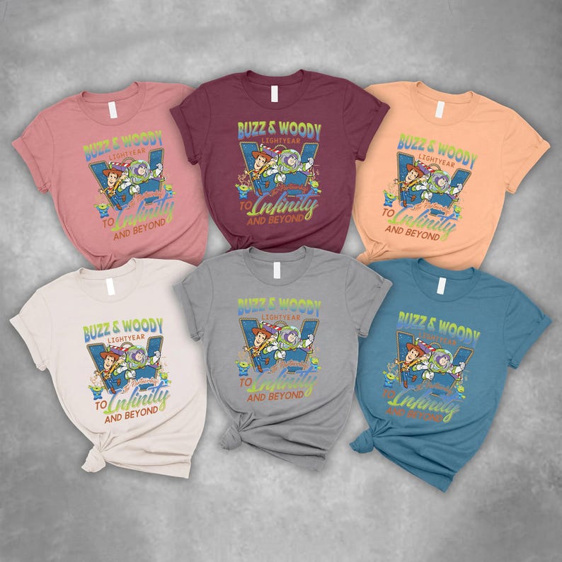 以下が含まれることがあります： さまざまな色の半袖Tシャツ6枚。各Tシャツには、バズ・ライトイヤーとウッディのグラフィックと「Buzz & Woody Lightyear To Infinity And Beyond」の文字がプリントされています。色はピンク、バーガンディ、ピーチ、白、グレー、ティールです。