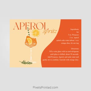 May include: A recipe card with an illustration of an Aperol Spritz cocktail. The card includes the ingredients and directions for making the drink. The ingredients are: 3 oz. Prosecco, 2 oz. Aperol, splash of soda water, and an orange slice. The directions are: Fill a wine glass with ice and refrigerate until chilled, add Prosecco, Aperol, and soda water, stir to combine, and garnish with an orange slice.