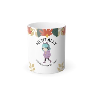 Könnte beinhalten: Ein Set aus drei Keramikbechern mit gesprenkelter, matter Oberfläche. Die Becher sind in Creme-, Hellgrau- und Dunkelgrautönen gehalten. Jeder Becher hat ein schlichtes, minimalistisches Design und einen abgerundeten Henkel. Höhe ca. 10 cm.