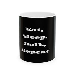 Könnte beinhalten: Schwarze Keramik-Tasse mit weißem Text "Eat, Sleep, Bulk, Repeat". Die Tasse hat einen weißen Innenraum und eine glänzende Oberfläche. Perfekt für Kaffee, Tee oder andere Getränke.