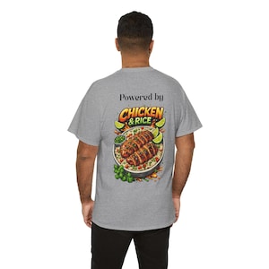 Peut inclure: Un t-shirt gris chiné avec le texte "Powered by Chicken & Rice" au-dessus d'un graphique coloré d'un plat de poulet et de riz. Le graphique comprend des quartiers de citron vert et des herbes vertes.