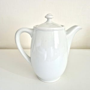 Vintage kaffekanna i porslin, vit. Elegant vit kanna med lock, tekanna, lantlig stil, retro.