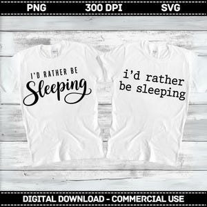 May include: Two white short-sleeved t-shirts featuring black text. The left shirt displays the words I'D RATHER BE Sleeping in a mix of block and script fonts. The right shirt displays the words i'd rather be sleeping in a simple block font.
