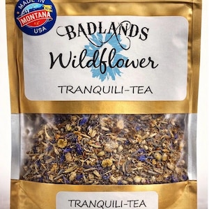 May include: A white ceramic mug with a black handle and the text "But First, Coffee" in a bold, black font. The mug is set against a neutral background, highlighting its simple design.