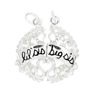 May include: Silver charm bracelet with two charms that say "lil sis" and "big sis" in black lettering. The charms are connected by a heart shape.