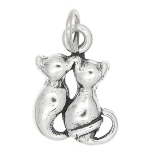 May include: Sterling silver charm featuring two cats facing each other, their heads touching. The cats are in a sitting position with their tails curled around each other.