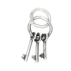 May include: A silver charm featuring three antique-style keys attached to a silver ring.