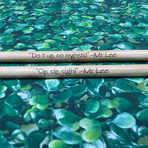 May include: Two wooden drumsticks with the text "Do it up, no regrets! -Mr. Lee" and "Sip, sip, sigh! -Mr. Lee" engraved on them.