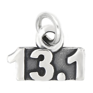 May include: Silver charm with a black background and white numbers that read "13.1". The charm has a loop at the top for attaching to a bracelet or necklace.