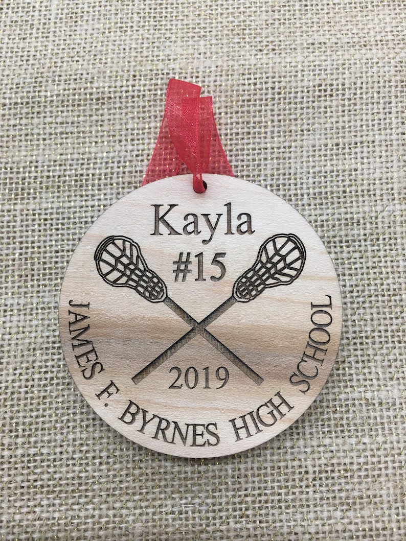 May include: A wooden lacrosse ornament with the name Kayla, number 15, and the text "James F. Byrnes High School 2019".