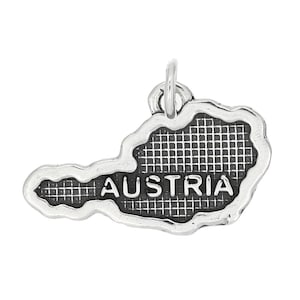 May include: Silver charm shaped like the outline of Austria with the word "AUSTRIA" inscribed on the charm.