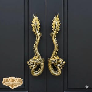 May include: Two ornate, gold-colored dragon door handles mounted on a black door. The handles are detailed with dragon heads and serpentine bodies, and are labeled "EraBrass Antique Hardware".