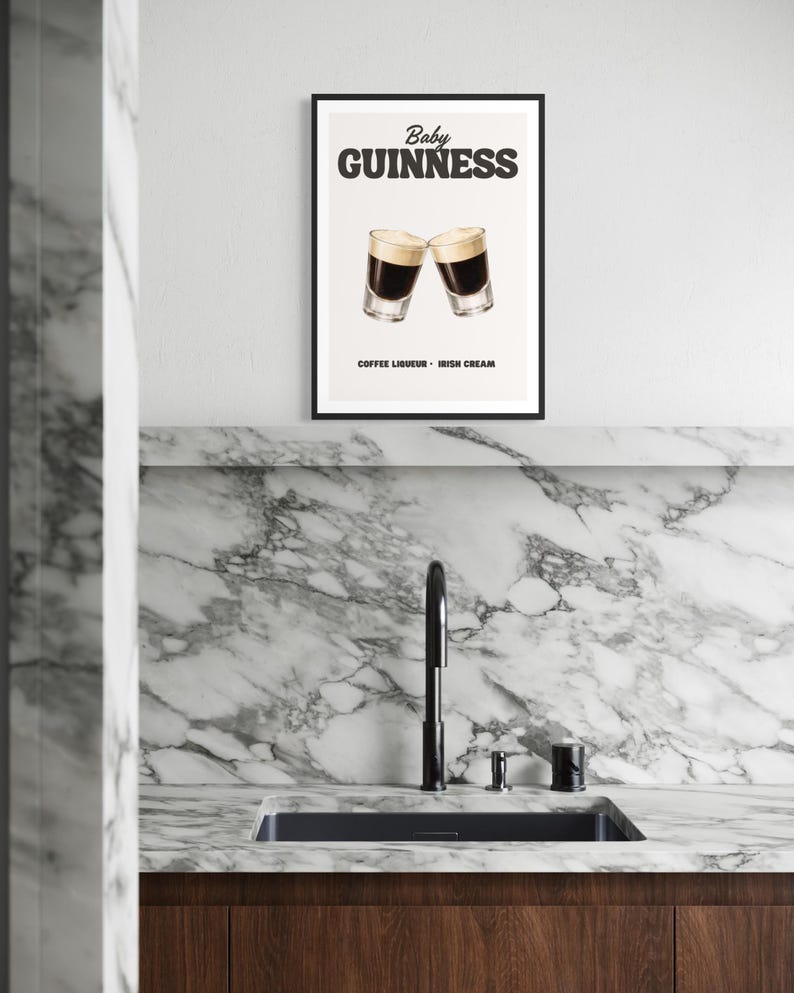 Puede incluir: Un cartel enmarcado con las palabras "Baby Guinness" encima de dos copas de c&oacute;ctel. El cartel tambi&eacute;n incluye el texto "Coffee Liqueur - Irish Cream". El cartel se muestra encima de un fregadero de cocina con un grifo negro y una encimera de m&aacute;rmol.
