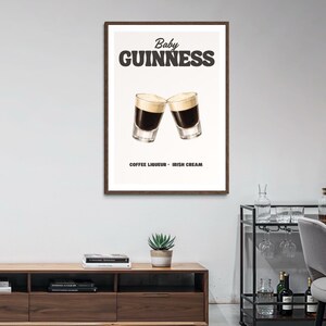 Puede incluir: Un p&oacute;ster enmarcado con una ilustraci&oacute;n del c&oacute;ctel "Baby Guinness". La imagen muestra dos vasos de chupito con licor de caf&eacute; y crema irlandesa en capas, con el texto "Baby Guinness" arriba y "Coffee Liqueur - Irish Cream" abajo.